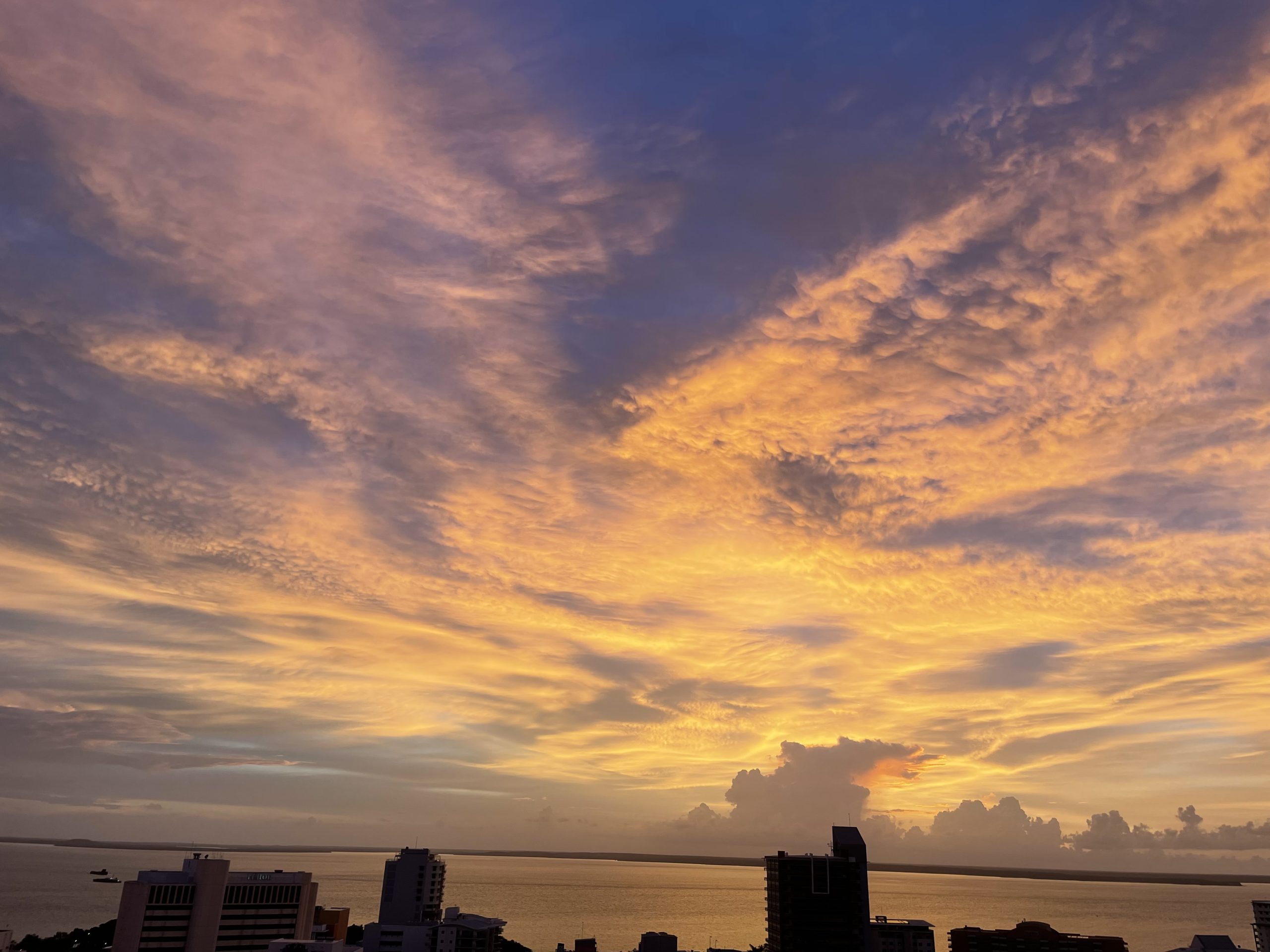 Sunset over a coastal city skyline