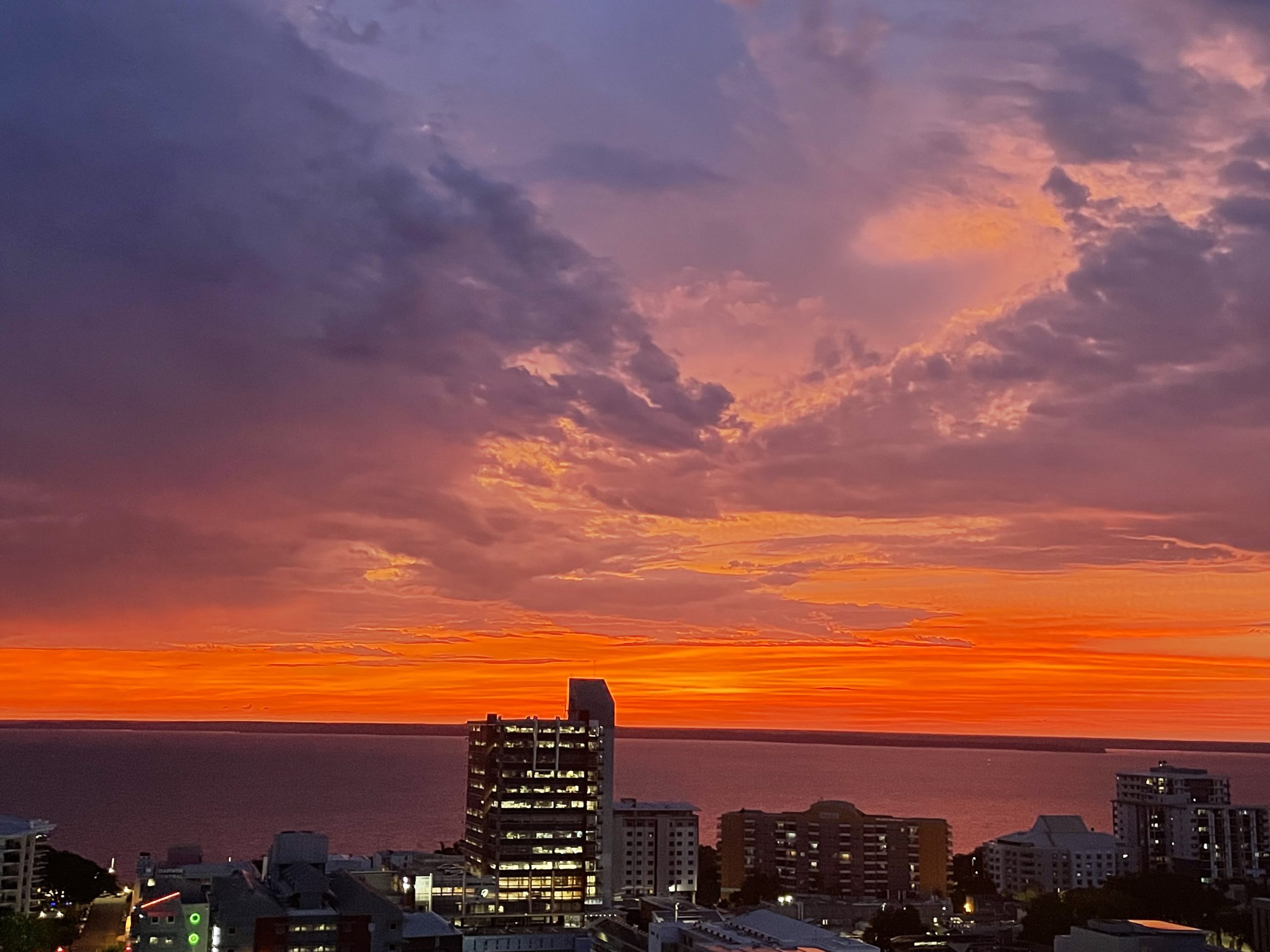 Sunset over a coastal city skyline